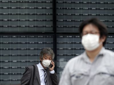 Мужчина стоит перед пустой электронной биржей. Фото: Eugene Hoshiko / AP Photo